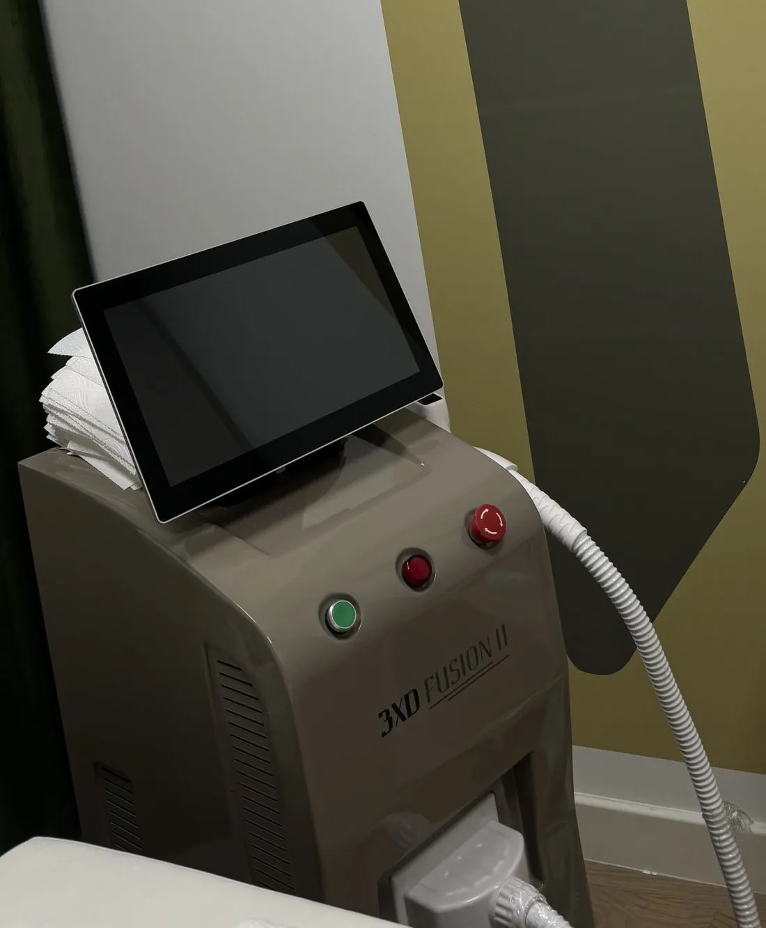 Aparat za lasersku epilaciju 3XD Fusion II ispred sivog luka na zidu